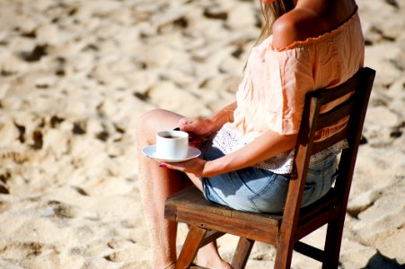 Girl Drinking Coffee On Beach photo