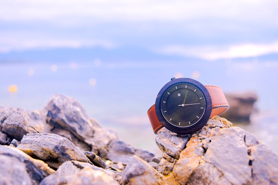 Brown And Black Round Analog Watch On Beige Rocks photo