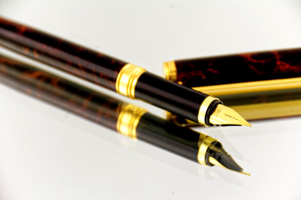 Elegant Fountain Pen Reflecting On Glass Surface