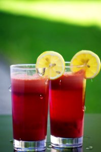 Clear Drinking Glass Filled With Red Liquid With Sliced Lemon photo
