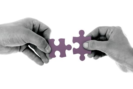 2 Hands Holding 1 Jigsaw Puzzle Piece Each