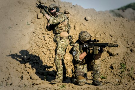 Two Men In Army Uniforms With Guns photo