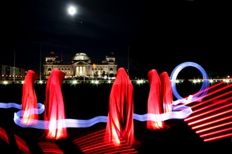 5 People Hiding Under Red Textile During Night photo