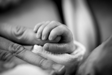 Grayscale Photography Of Baby Holding Finger photo
