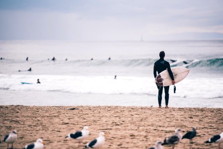 Man With Surfboard Looking At The Waves photo