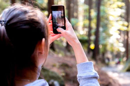 Woman Using Her Smartphone While Taking The Picture The Forest photo
