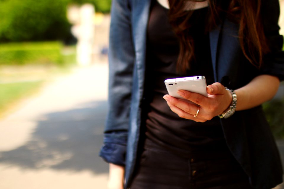 Woman Holding White Smartphone