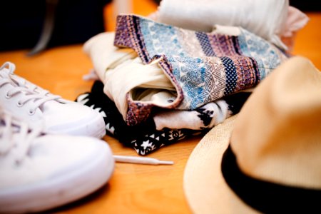 Brown Fedora Hat Beside White Sneakers And Blue Textile photo