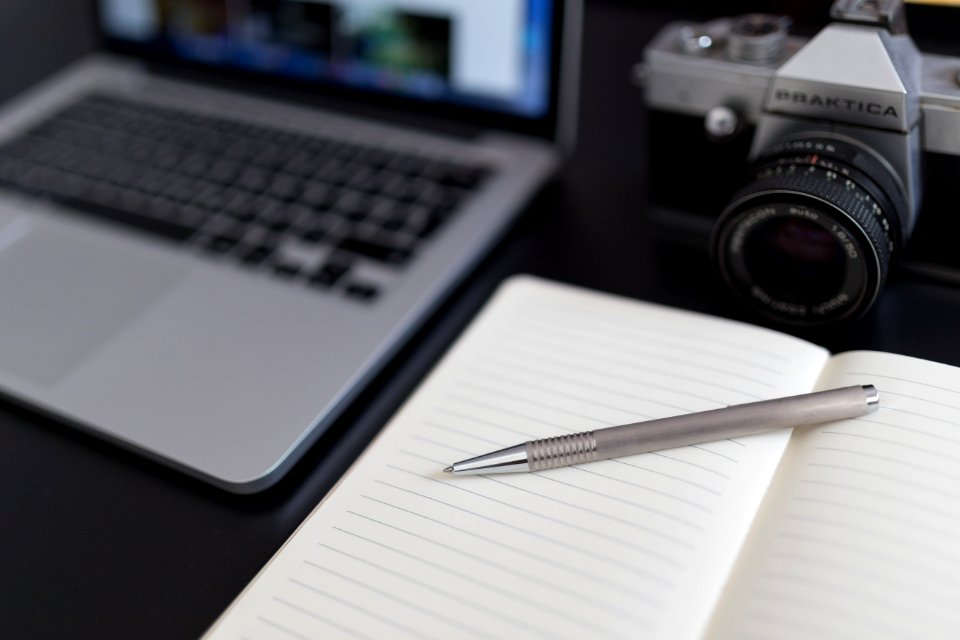 Black And Gray Dslr Camera Beside Macbook Pro