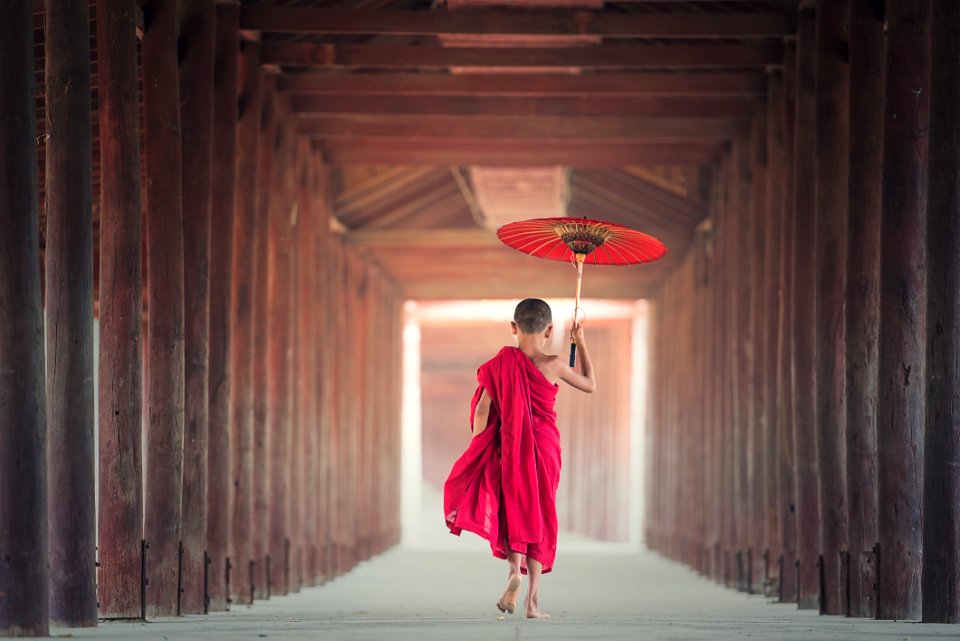 Monk With Umbrella In Hallway