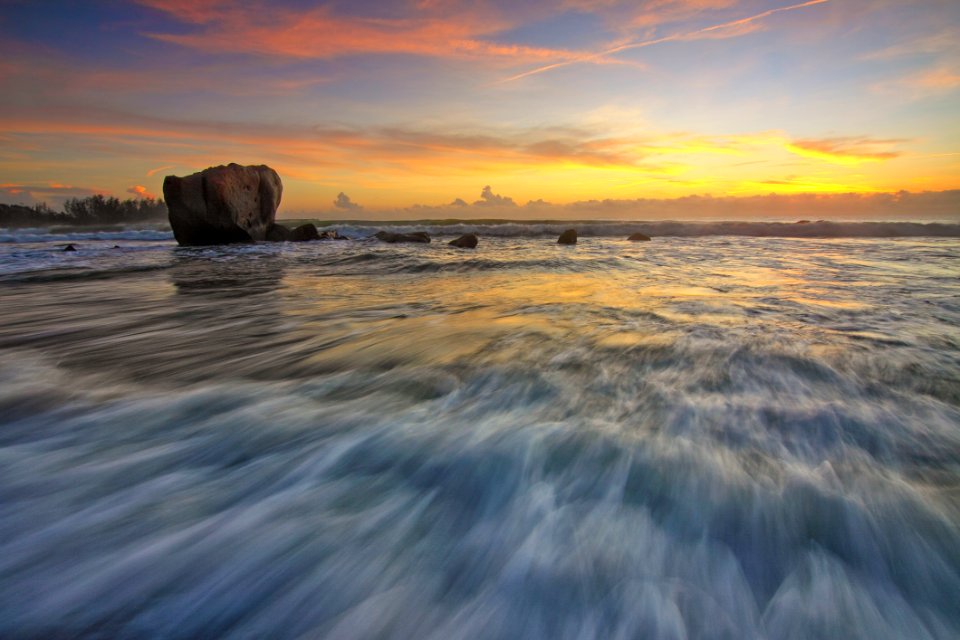 Waves On Beach With Rock At Sunset