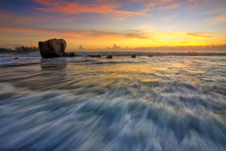 Waves On Beach With Rock At Sunset photo
