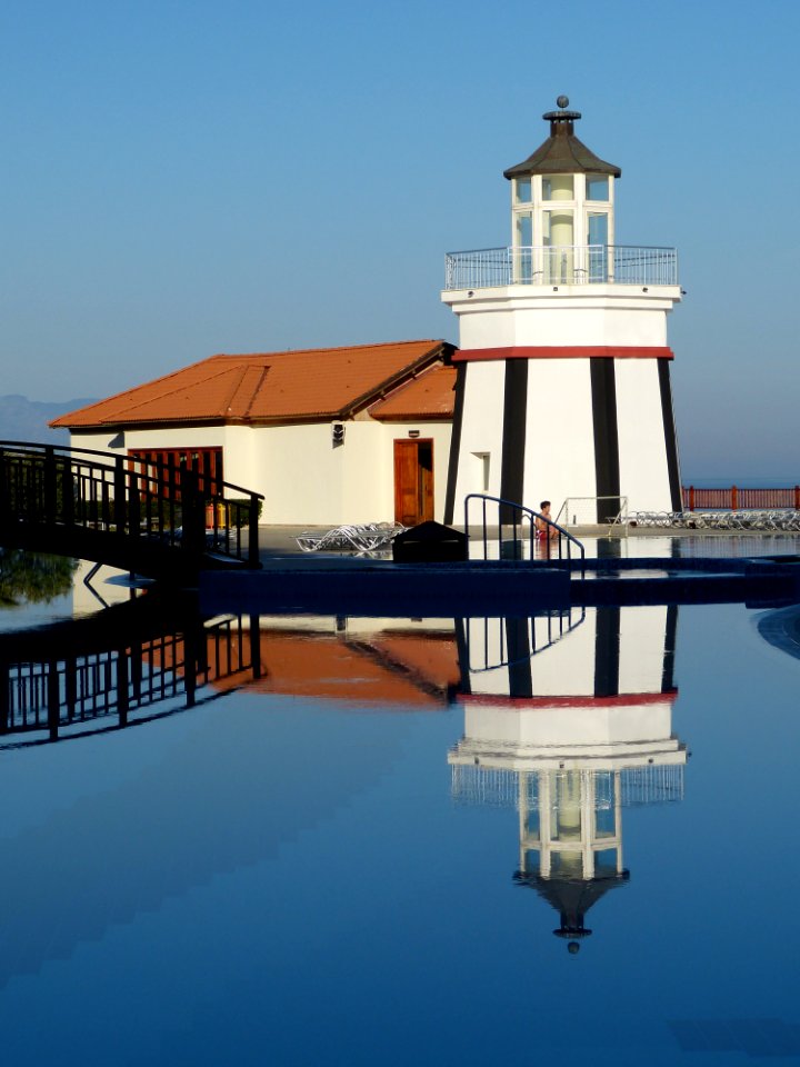 Lighthouse Reflecting In Blue Waters