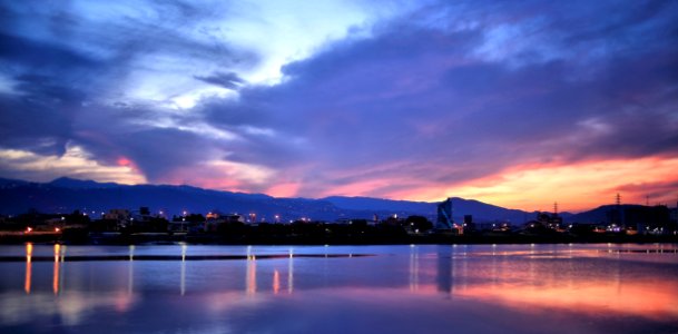 Blue Orange And White Sky Over Water And Landscape photo