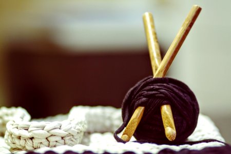 Brown Wooden Rod And Purple Yarn Ball Beside White Braided Cloth photo