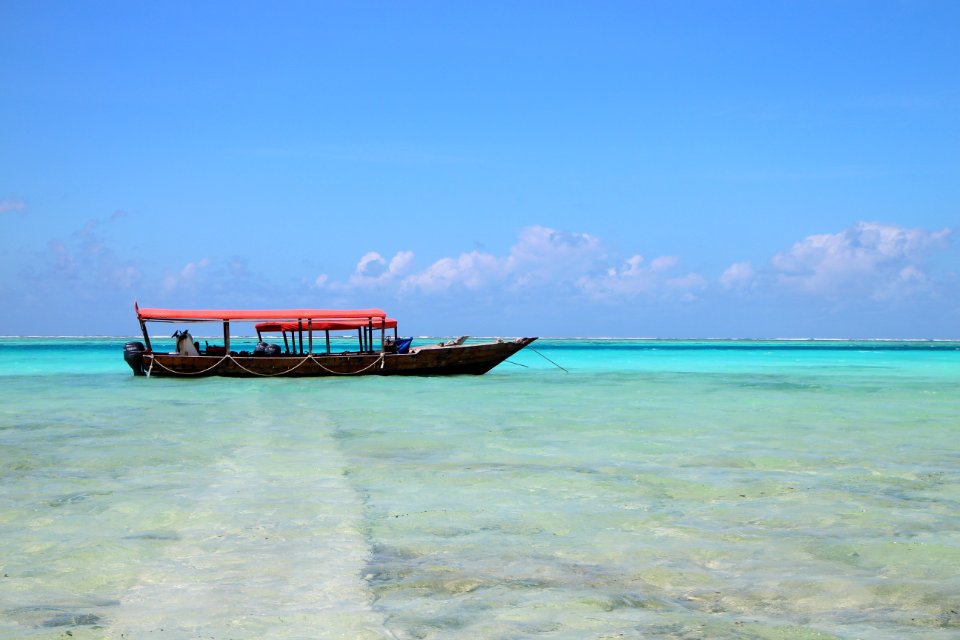 People On Black Boat Under Blue Sky At Daytime