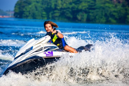 Man In Safety Vest Riding A Personal Watercraft During Daytime photo