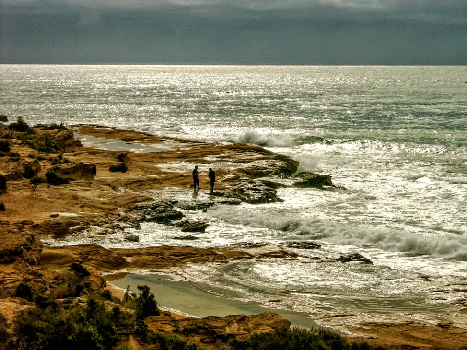 Men On Rocky Beach In Mediterranean