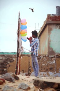 Man In White Gray And Teal Dress Shirt Standing In The Rock During Day Time photo