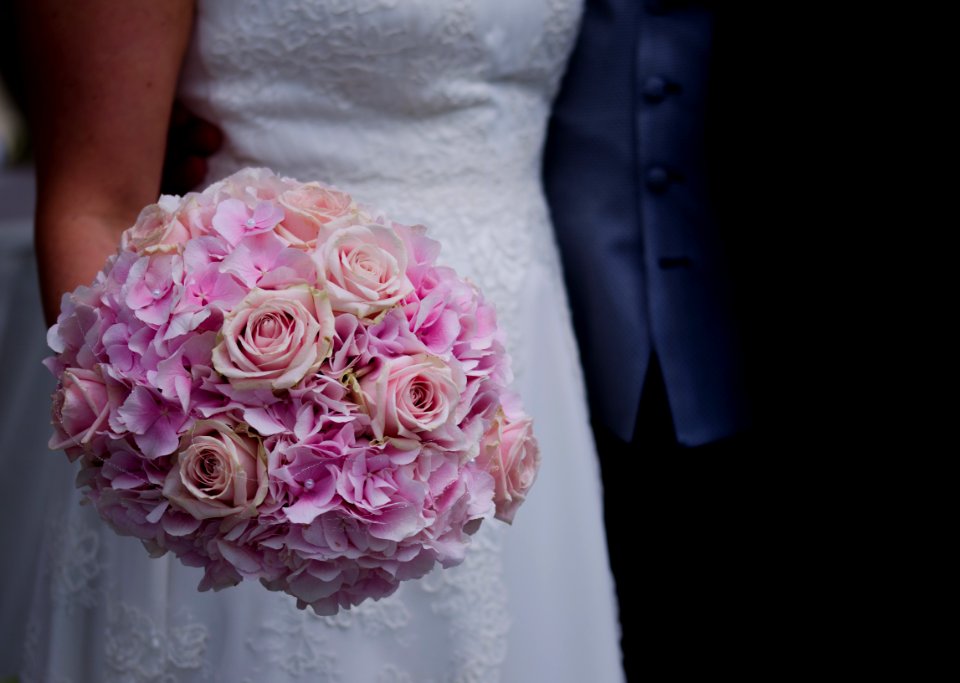Woman In White Wedding Dress Holding A Bouquet Of Flowers