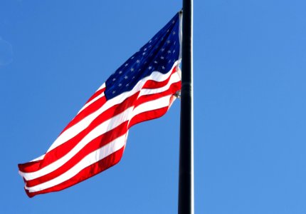 Low Angle View Of Flag Against Blue Sky