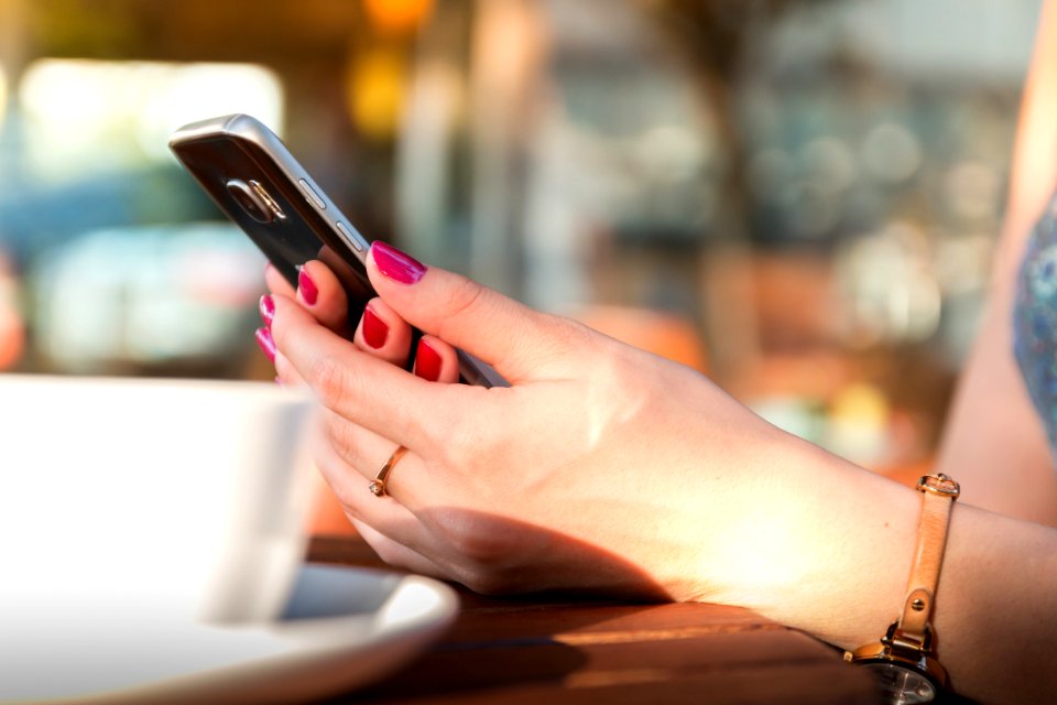 Person Holding A Black Smartphone Wearing A Brown Leather Strap Watch