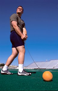 Man Wearing Grey Shirt Swinging Orange Ball photo