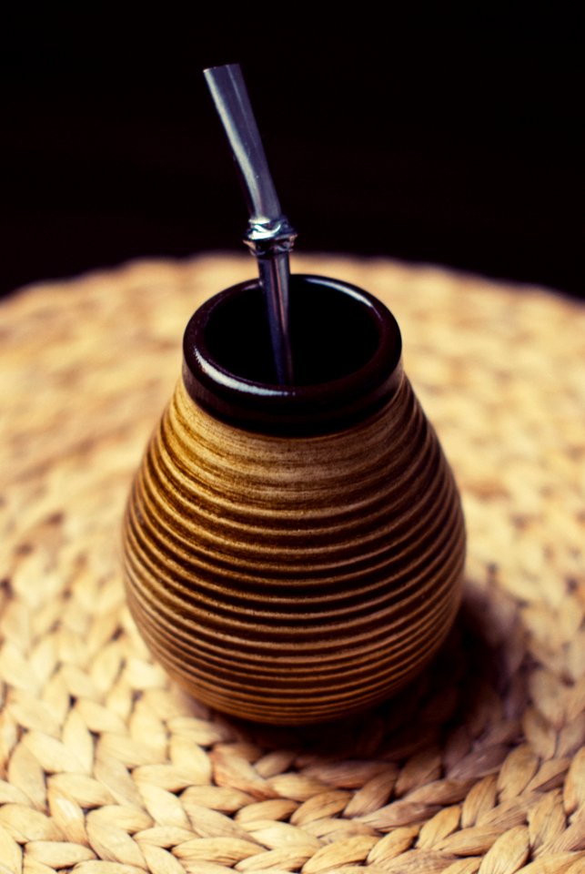 Brown And Beige Ceramic Container With Silver Inside On Brown Braided Textile