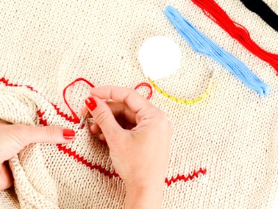 Person Embroidering A Beige Textile photo