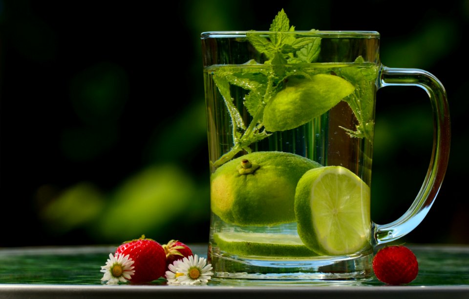 Green Round Fruit On Clear Glass Mug With Water