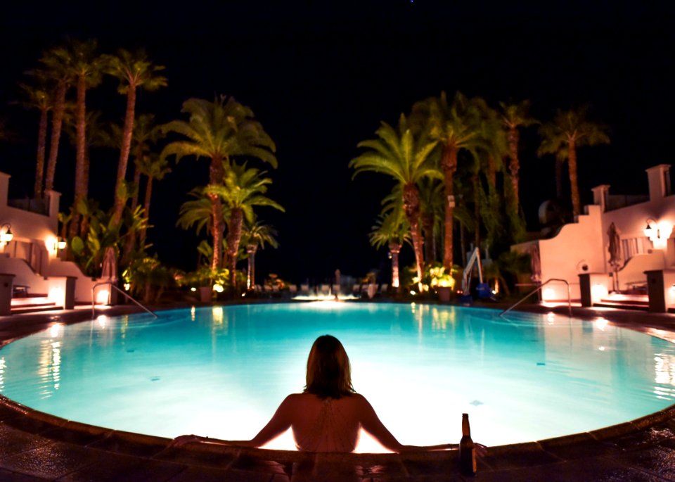 Topless Woman In Pool Facing Trees During Night Time
