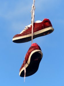 Red And White Hanging Sneakers During Daytime