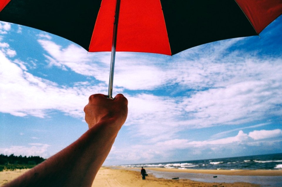 Umbrella In Hand On A Beach