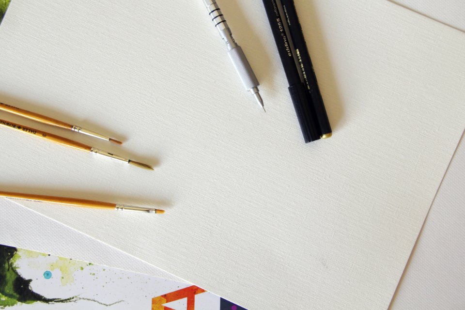 Brown Paintbrush Beside Black And Silver Ballpen On White Printing Paper