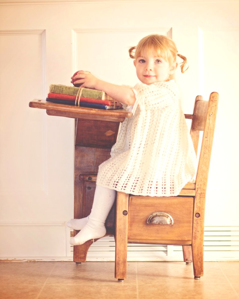 Girl In White Dress Sitting On Brown Wooden Chair