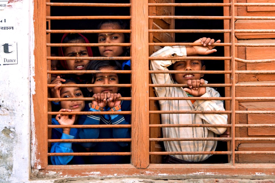 5 People Leaning On Brown Railings Of Window
