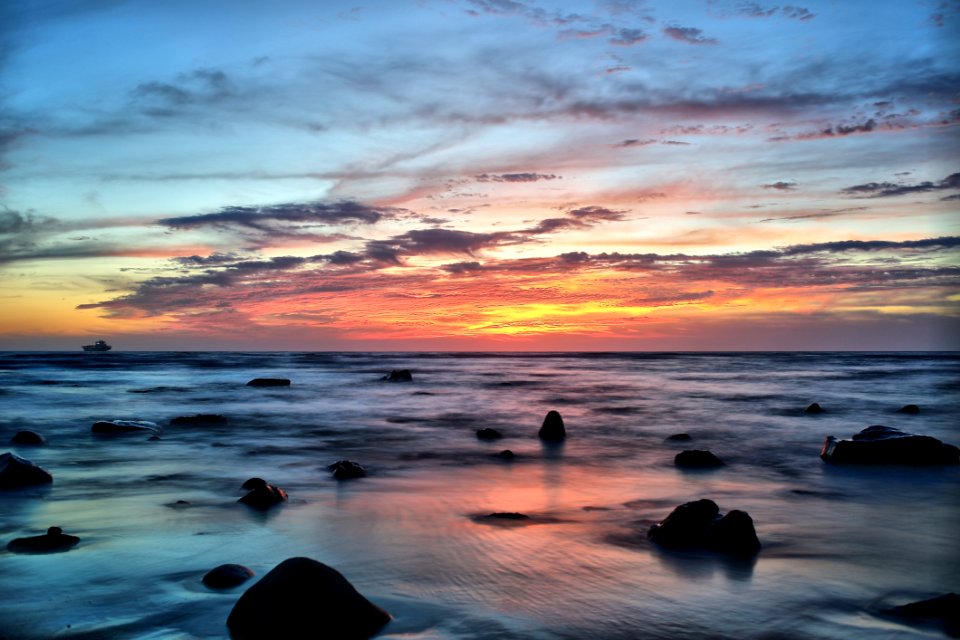 Silhouette Of Stones On Seawater During Sunset