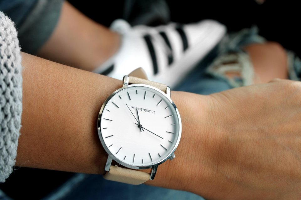 Beige Strap Silver Round Analog Watch Behind Adidas White And Black Superstar