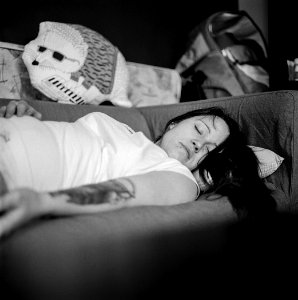 Woman In White Shirt Sleeping On Gray Fabric Sofa