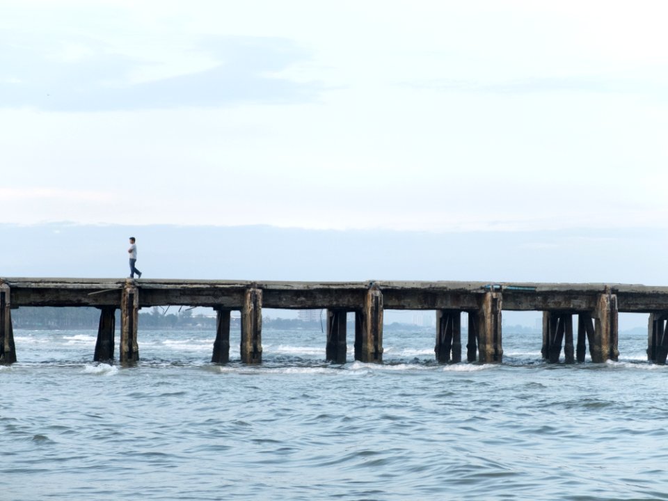 Person Walking On Ocean Pier photo