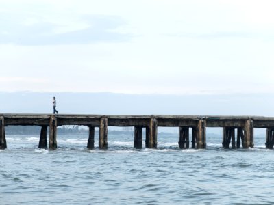 Person Walking On Ocean Pier