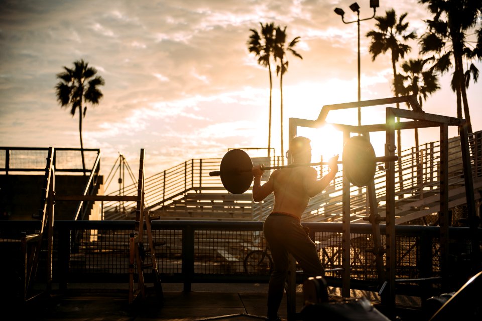 Bodybuilder Exercising At Sunset