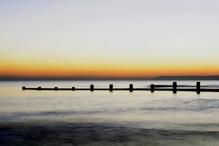 Scenic View Of Sea Against Clear Sky During Sunset photo