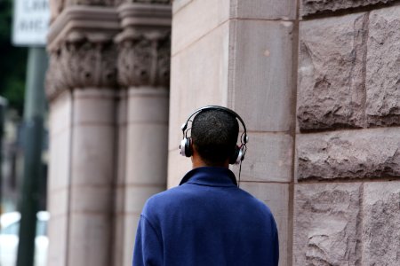 Man In Blue Long Sleeve Coat Wearing Silver And Black Headphones During Daytime photo