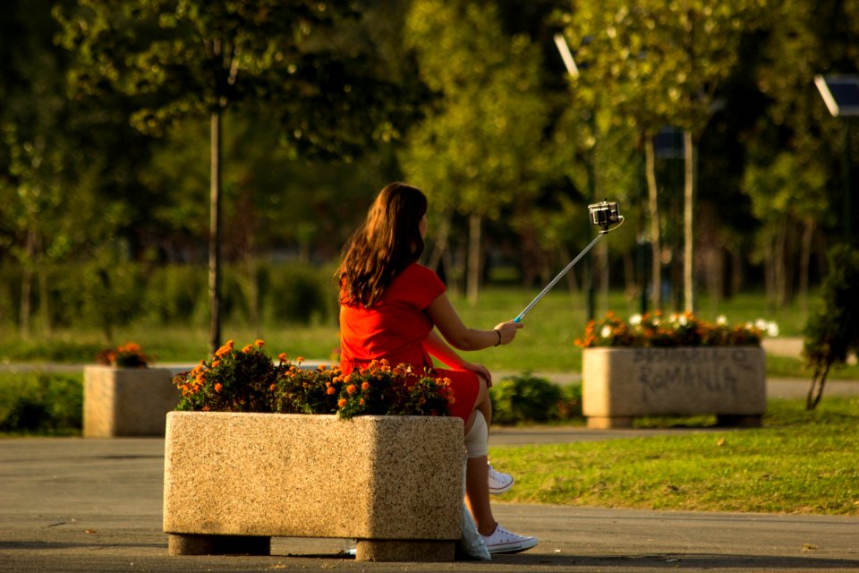 Girl Using Selfie Stick In Park