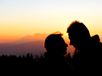 Silhouette Couple Kissing Against Sky During Sunset photo