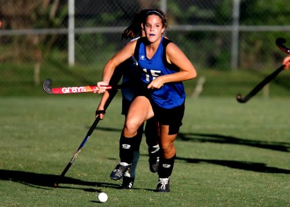 Woman Wearing Blue And Black Jersey Holding Field Hockey photo