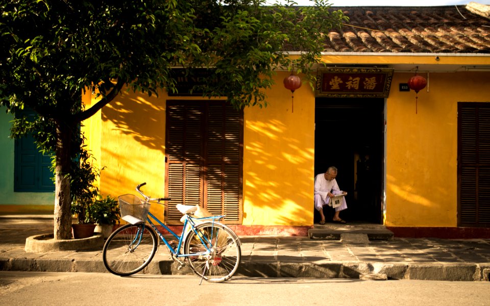 Asian Home With Man Reading Paper And Bicycle