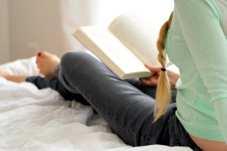 Woman Reading Book In Bed photo