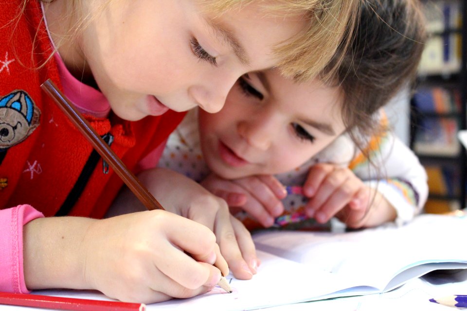 Girls On Desk Looking At Notebook
